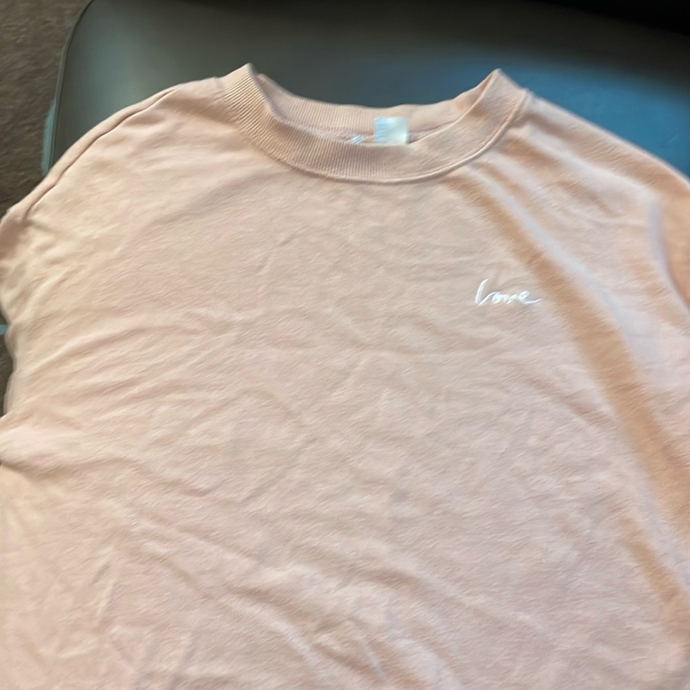 Pink long sleeve top with “love” embroidered on chest.